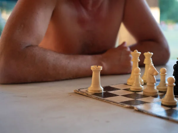 Two people playing chess on an old cardboard board