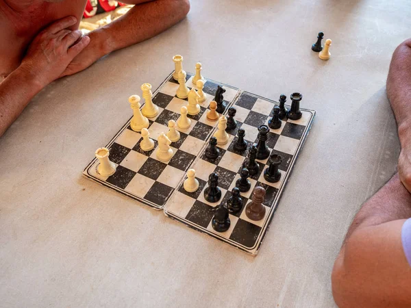 Zwei Personen spielen Schach auf einer alten Pappe — Stockfoto