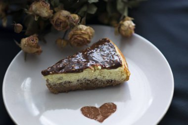 Çikolata ve çiçek siyah arka plan üzerine cheesecake