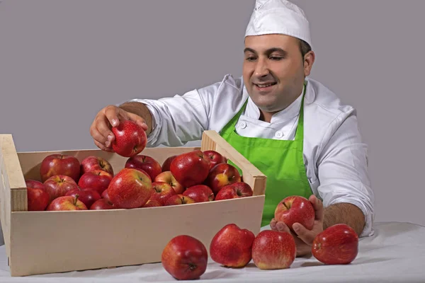 Fruit seller placing red apples in a box