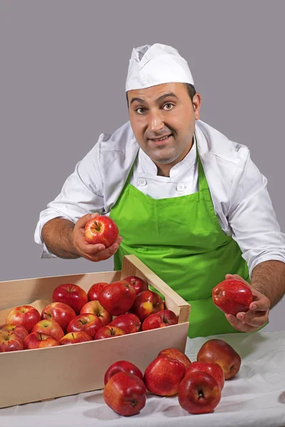 Fruit seller offering a red apple