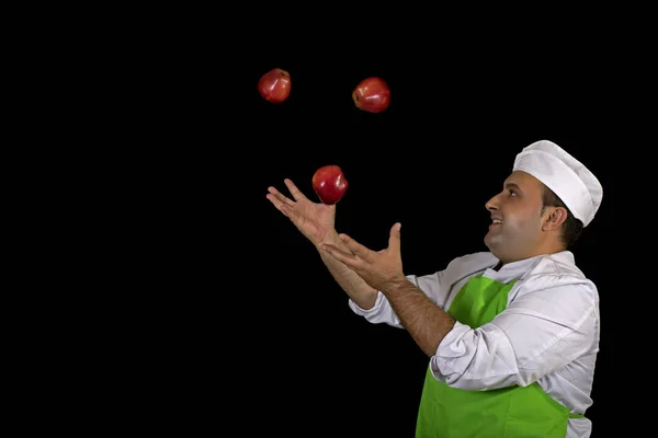 水果销售商在黑色背景上摆弄三个红苹果 — 图库照片