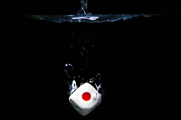 Dice with the number two face in the water with black background