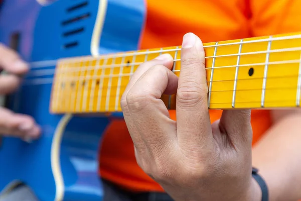 Руки играют на гитаре, человек играет на электрогитаре крупным планом . Лицензионные Стоковые Фото