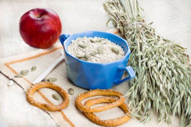 tabak yulaf ezmesi, kırmızı elma, Kuru bisküvi, çuval bezi çerçevede yulaf kulakları closeup