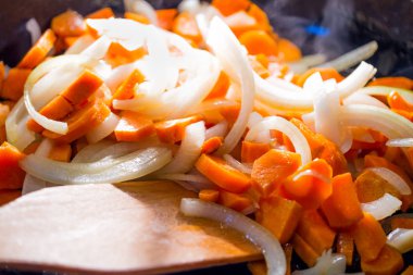 soğan halkaları ve havuç güveç sıcak bir tavada, yakın çekim