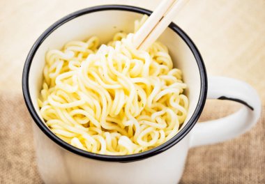 Bir demir kupa closeup ahşap sopa üzerinde yara içinde dalgalı erişte