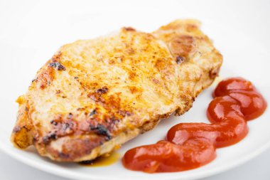 Biftek beyaz tabakta domates sosu yakın. Yan görünümü. Yakın çekim