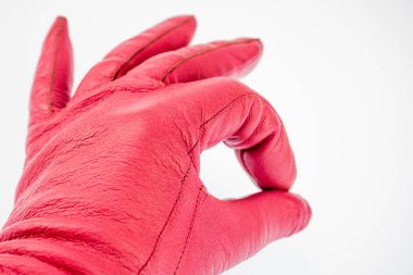 El bir jest gösterilen bir deri eldiven pembe, her şey yolunda. Arka plan beyaz yakın çekim