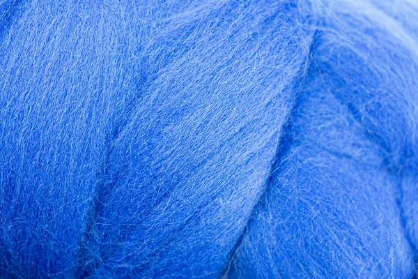 The texture of wool, cordos, merino wool. Color bright blue on the background screensaver, close-up