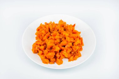 Karamel, beyaz bir arka plan üzerinde beyaz bir plaka üzerinde kabak küpleri. Üst, yan, yakın çekim görünümü