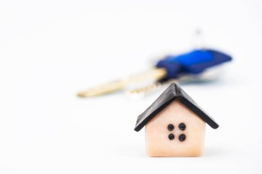 Sağ alt köşede plastik ev yakın çekim düzeni. Arka planda, dairenin anahtarları bulanık. Arka plan beyaz, bulanık. Boşaltmak