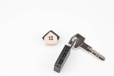 Model plastik, evi yakın çekim. Yakınlarda bir sır ile bir asma kilit ile daire anahtarı bulunmaktadır. Arka plan beyaz, imza için bir yer var.