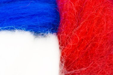Aydınlık arka. Bayrak ekran koruyucu doku yün kavramı. Ulusal bayrakların renkleri mavi, beyaz, kırmızı. Yünden bayrak dedikodu. Yakın çekim