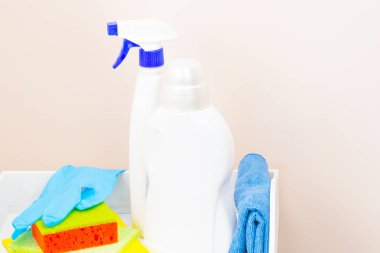 Bahar temizleyiciler şişe kullanımı ile ev temizliği. Temizlik ve konfor kavramını. Açık renkli beyaz tepsi, deterjanlar, tuvalet bezi. Portre yan görünüm