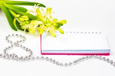 Uluslararası Kadınlar Günü tebrik ediyorum. Beyaz bahar çiçekleri, sümbül. Defter bir pembe kapak bir yer imza için. Şekil 8 yüzeyi gümüş boncuk ile dışarı atılır. Bahar tatil kavramı üzerinde Mart 8. Backgrou