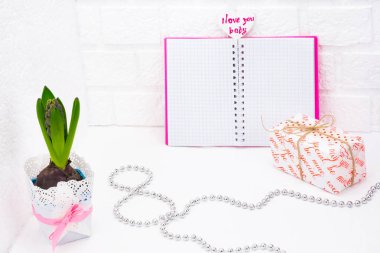 Dünya Kadınlar gününde romantik selamlar. Vintage sarmalayıcı bahar çiçeklenir. Bir tencerede beyaz sümbül. Hediyeler şenlikli ambalaj kutuları. Defter pembe bir kapak ile imza için bir yer yoktur. Gümüş boncuk kaplı 8 bul. Kavramı o