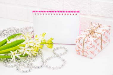 Dünya Kadınlar gününde romantik selamlar. Vintage sarmalayıcı bahar çiçeklenir. Bir tencerede beyaz sümbül. Hediyeler şenlikli ambalaj kutuları. Defter pembe bir kapak ile imza için bir yer yoktur. Gümüş boncuk kaplı 8 bul. Kavramı o