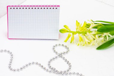 Uluslararası Kadınlar Günü tebrik ediyorum. Beyaz bahar çiçekleri, sümbül. Defter bir pembe kapak bir yer imza için. Şekil 8 yüzeyi gümüş boncuk ile dışarı atılır. Bahar tatil kavramı üzerinde Mart 8. Backgrou