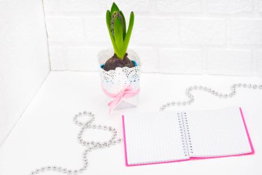 Uluslararası Kadınlar Günü tebrik ediyorum. Beyaz bahar çiçekleri, sümbül. Defter bir pembe kapak bir yer imza için. Şekil 8 yüzeyi gümüş boncuk ile dışarı atılır. Bahar tatil kavramı üzerinde Mart 8. Backgrou