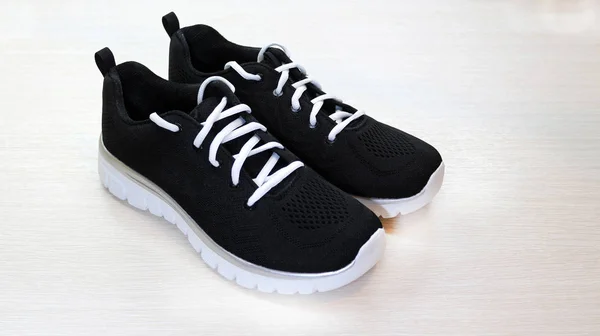 Black sport unisex sneakers with white sole and white laces on w — Stock Photo, Image