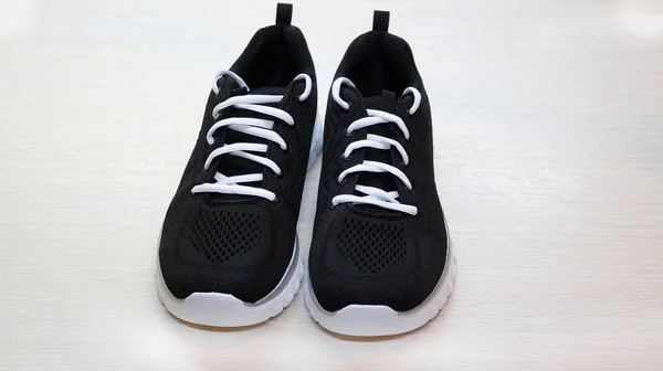 Μαύρο σπορ unisex αθλητικά παπούτσια με λευκή σόλα και λευκά κορδόνια στο w — Φωτογραφία Αρχείου