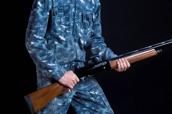 Ein Soldat in Militäruniform mit einer Schrotflinte. Kriegsspiele. Vorbereitung auf die Jagd im Frühling, Herbst. Soldat oder Jäger auf schwarzem Hintergrund, isoliert, Kopierraum. Junger Mann mit Waffe. — Stockfoto