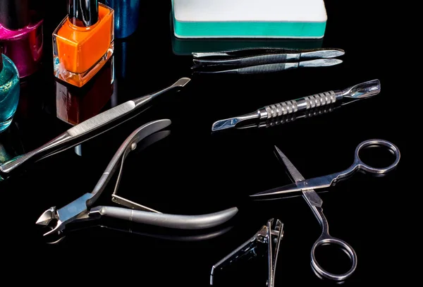 Manicure and pedicure tools on black background, isolated. Equipment for beauty shop, cosmetic salon or beauty parlour. Manicure tools in the beauty salon. Equipment for manicure or pedicure salon.