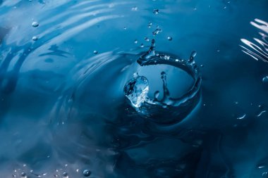 Bir damla su. Mavi su damlası. Düşen su. Su sıçraması yakın çekim. Yağmur yakın