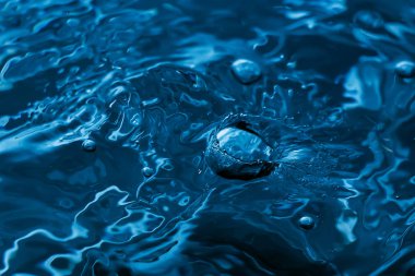 Bir damla su. Mavi su damlası. Düşen su. Su sıçraması yakın çekim. Yağmur yakın