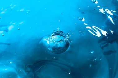 Su sıçraması yakın çekim. Bir damla su. Mavi su damlası. Düşen w