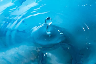 Su sıçraması yakın çekim. Bir damla su. Mavi su damlası. Düşen w