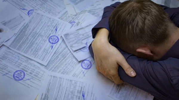 The state of crisis, failure and depression. Work with documents. Frustrated guy at the Desk with documents. Problems with documents, debts on loans and tax operations. Confiscation — Stock Photo, Image