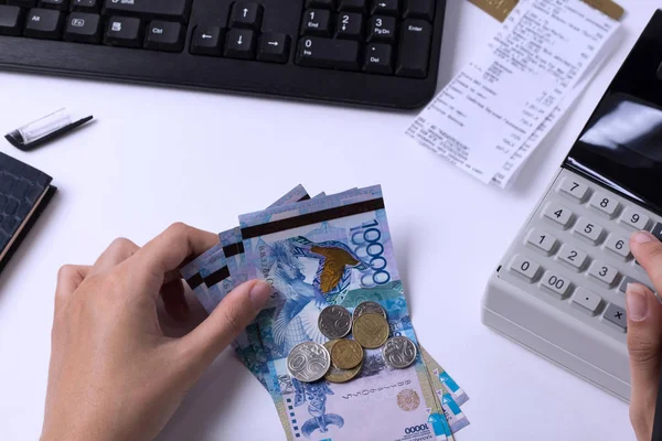 Tenge bij de kassier accountant in de handen van de werkplek op kantoor. De kassier telt het geld KZT op de werkplek in Kazachstan. — Stockfoto