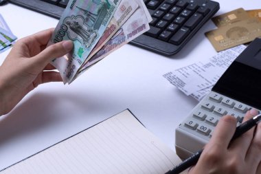 Rusya'da ücret sorunu. Muhasebeci kasiyer ruble para sayar ve raporları ve ifadeleri doldurur. İşyerinde ofis çalışanı.