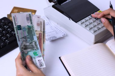 Rusya'da ücret sorunu. Muhasebeci kasiyer ruble para sayar ve raporları ve ifadeleri doldurur. İşyerinde ofis çalışanı.