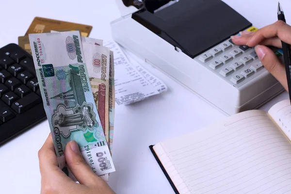 La question des salaires en Russie. Caissier comptable compte l'argent en roubles et remplit les rapports et les relevés. Employé de bureau sur le lieu de travail . — Photo