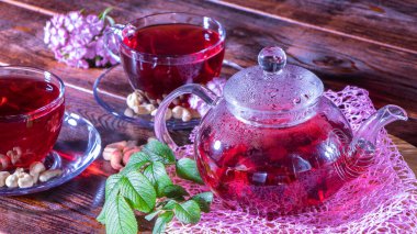 Rahat bir evde hoş kokulu sıcak lüks çay. Rahatlatıcı içecek. Çaydanlık, fincanlar, fındık, karanfil çiçekleri ve yeşil tıbbi yapraklar. Japon ve Zen tarzında çay seremonileri ve gelenekler