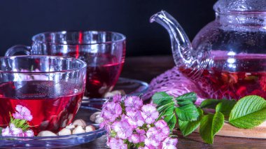 Çaydanlık, fincanlar çay, fındık, karanfil çiçekleri ve yeşil tıbbi yapraklar. Japon ve Zen tarzında çay seremonileri ve gelenekler. Sıcak, lüks çay ve hoş bir koku. Rahat bir evde. Rahatlatıcı bir içecek.