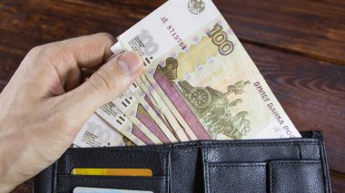 Rus rublesi olan arsa, kredi kartlarıyla birlikte el altından alınıyor. Rus Rublesinin kağıt banknotları. Rusya Bankası 'ndan kredi alıyorlar. Ruble döviz kurunun düşmesi veya büyümesi