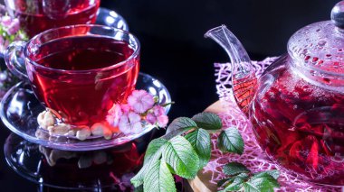 Rahat bir evde hoş kokulu sıcak lüks çay. Rahatlatıcı içecek. Çaydanlık, fincanlar, fındık, karanfil çiçekleri ve yeşil tıbbi yapraklar. Japon ve Zen tarzında çay seremonileri ve gelenekler