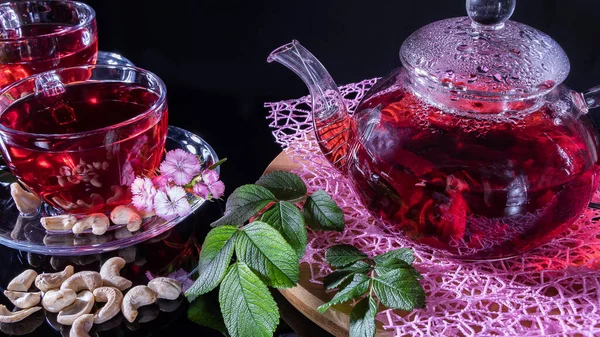 Yeşil çay yaprakları ya da şifalı bitki yaprakları bir çaydanlık, fincanlar, fındık ve karanfil çiçekleri ile birlikte masanın üzerinde yatar. Çay partileri, çay gelenekleri ve törenler. Doğunun Zen gelenekleri