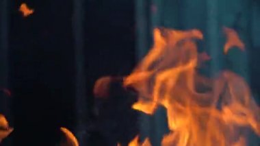 Ateş ve alevlerin yavaş çekim videosu. Bir ateş çukuru, yanan gaz ya da alevlerle yanan benzin. Yakın çekim ve kıvılcımlar, ateş desenleri.