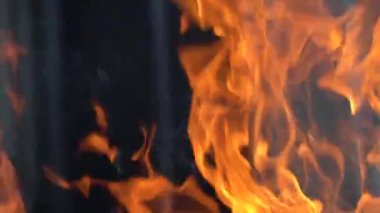 Ateş ve alevlerin yavaş çekim videosu. Bir ateş çukuru, yanan gaz ya da alevlerle yanan benzin. Yakın çekim ve kıvılcımlar, ateş desenleri.