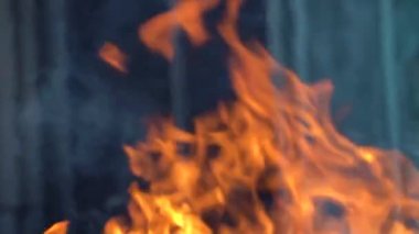 Ateş ve alevlerin yavaş çekim videosu. Bir ateş çukuru, yanan gaz ya da alevlerle yanan benzin. Yakın çekim ve kıvılcımlar, ateş desenleri.
