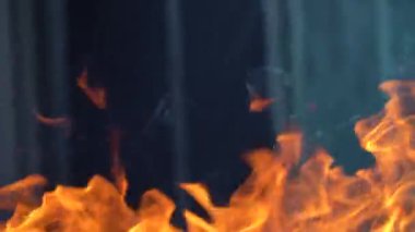 Ateş ve alevlerin yavaş çekim videosu. Bir ateş çukuru, yanan gaz ya da alevlerle yanan benzin. Yakın çekim ve kıvılcımlar, ateş desenleri.