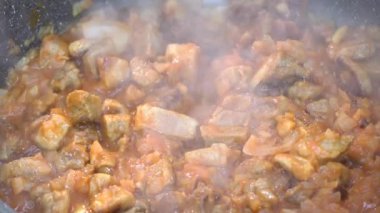 Etli, soğanlı, domatesli ve sebzeli sos, sos ya da sos yapmak için 4K video tarifi. Yüksek sıcaklıkta bir kızartma tavasında. Etli sebze güveci.