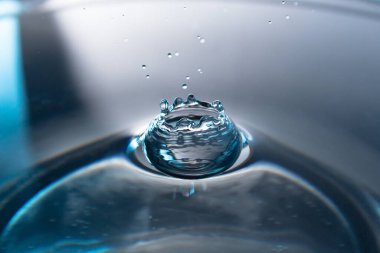 Taçlı bir su salgınının soyutlanması. Su seviyesi yakınlaşır. Donmuş su damlası yüksek hızda fotoğraflanır. Hava kabarcıklarıyla damlayan sıvı.