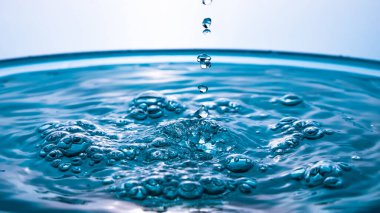 Soyut bir su salgını. Yakın plan su sıçraması. Donmuş su damlası yüksek hızda fotoğraflandı. Hava kabarcıklarıyla damlayan sıvı. Doğa ya da duvar kağıdı. Donmuş sıvı sıçraması.