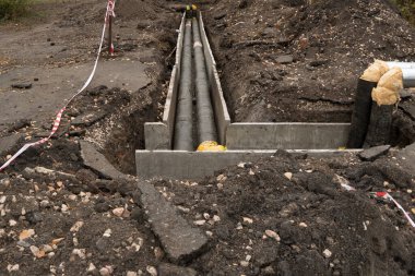 Kanalizasyon borularının, su kaynaklarının ya da drenaj sisteminin tamiri. Ekipmanları çalıştırmak için yer altında. Kalın su boruları zemindeki bir çukurda beton bir kutuda yatıyor, ısınma sezonuna hazırlanıyor.